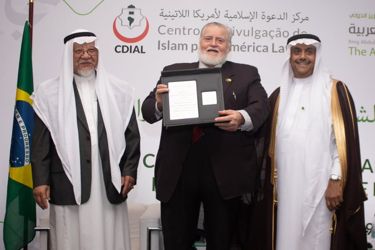Atividades do MARKAZ - 2026 14 Representantes exibindo homenagem diante de painel institucional