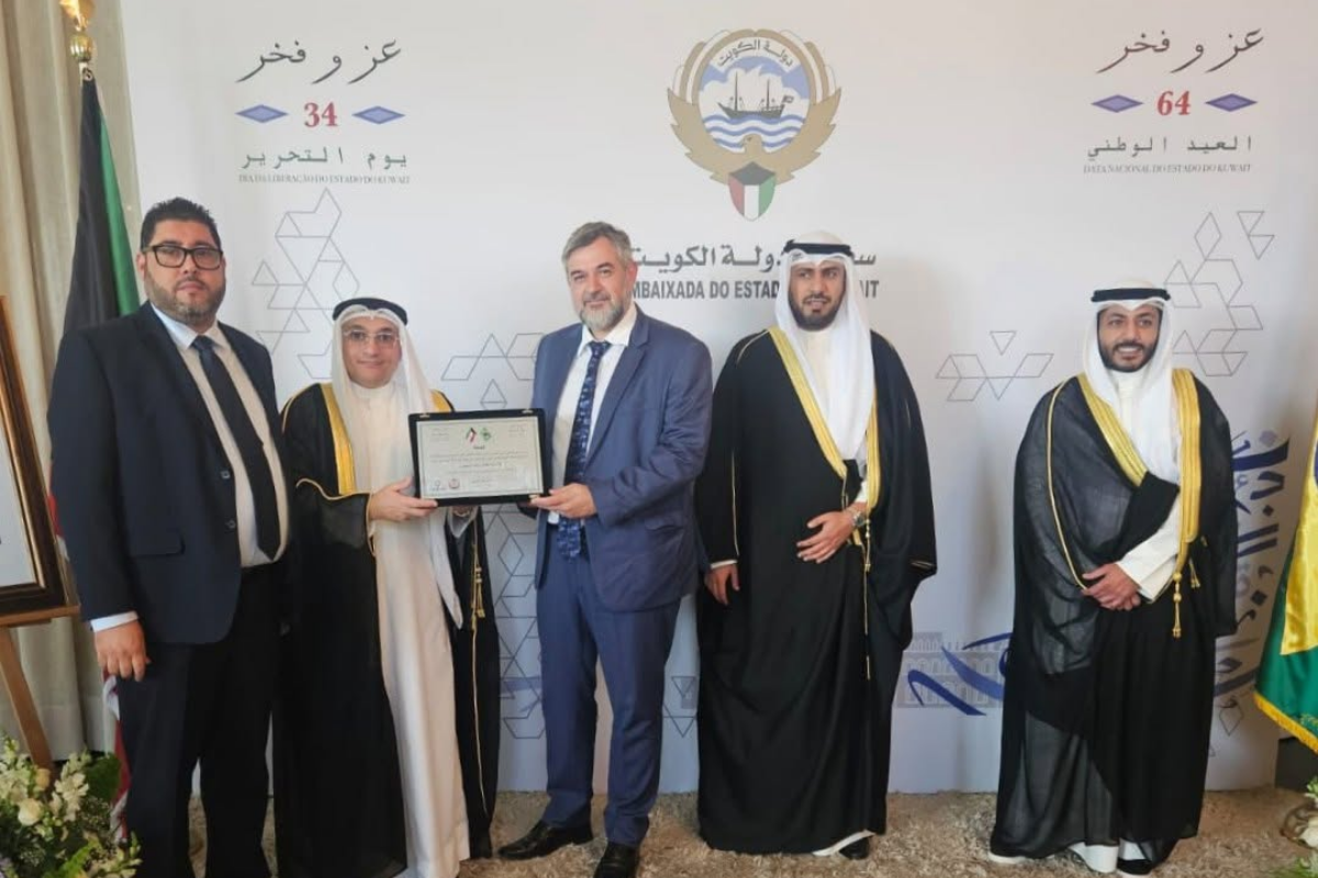 Atividades do MARKAZ - 2026 71 Representantes reunidos diante de painel da Embaixada do Kuwait