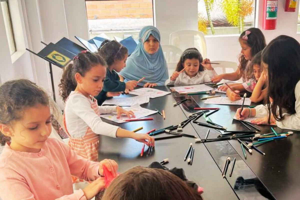 Atividades do MARKAZ - 2026 27 Crianças realizando atividades de desenho e aprendizado à mesa